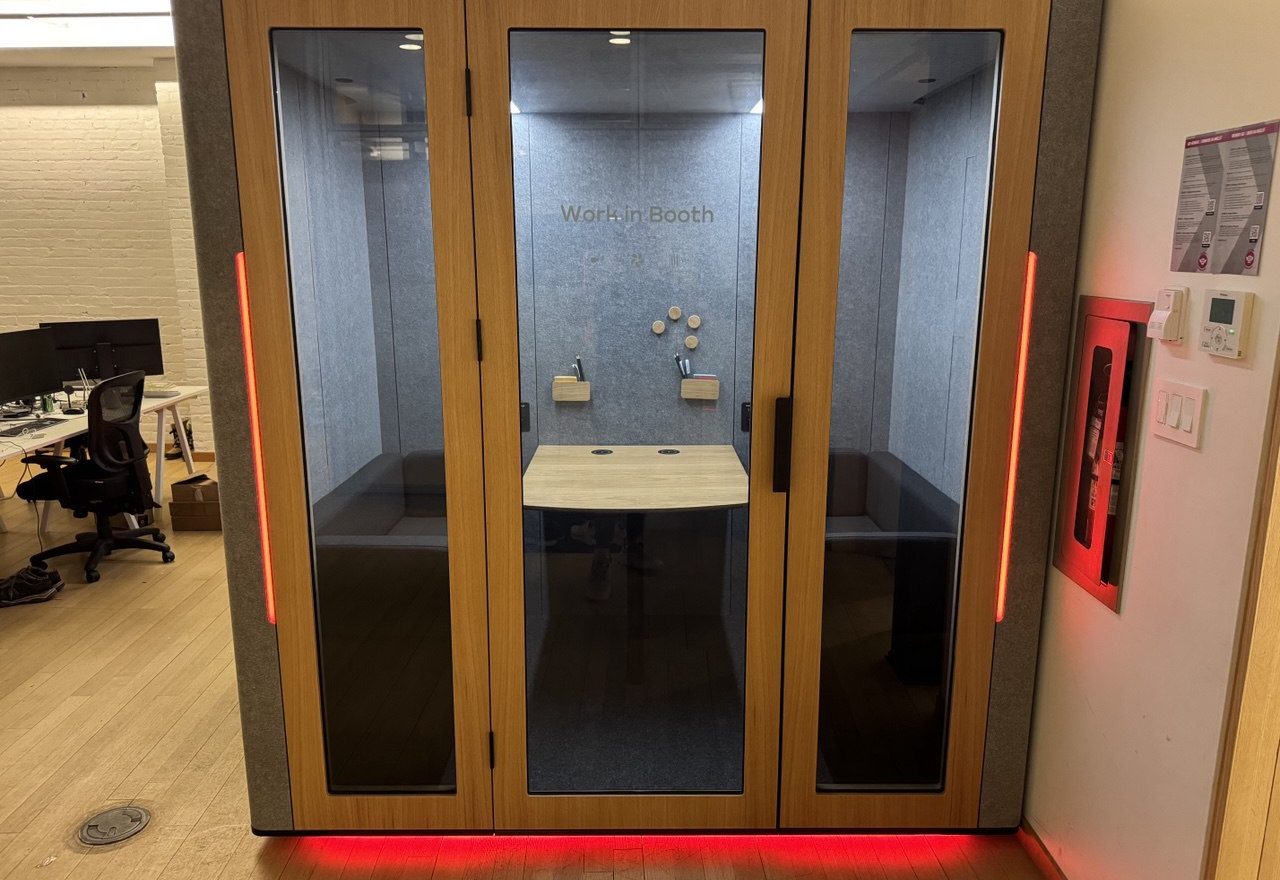Meeting pod installed on hardwood floors in a brick loft office in Toronto