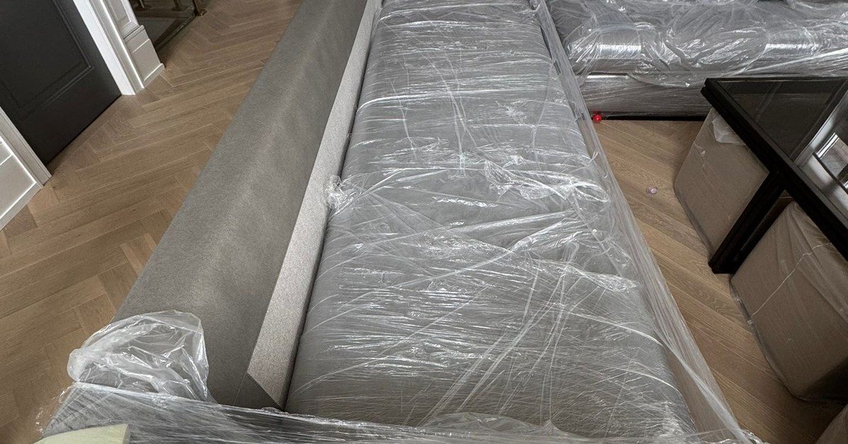 Sofa wrapped in protective film and blankets by Grey Peacock movers in Toronto